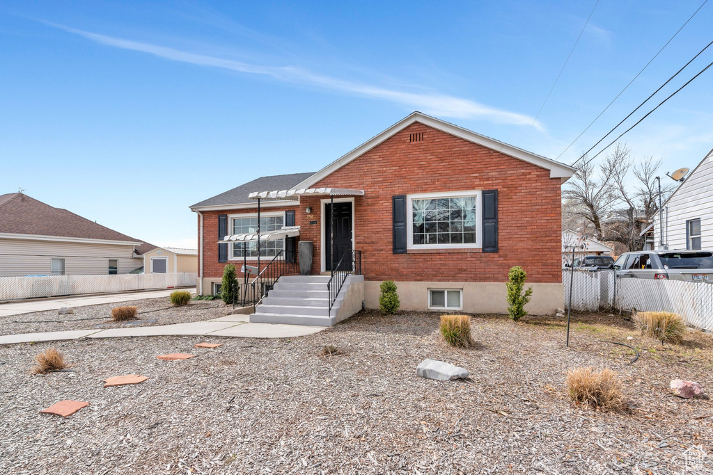 View of front facade with brick siding and fence