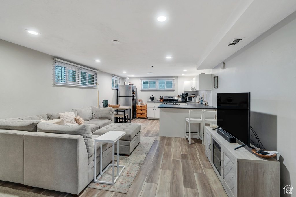 Living area featuring visible vents, light wood-style flooring, and recessed lighting