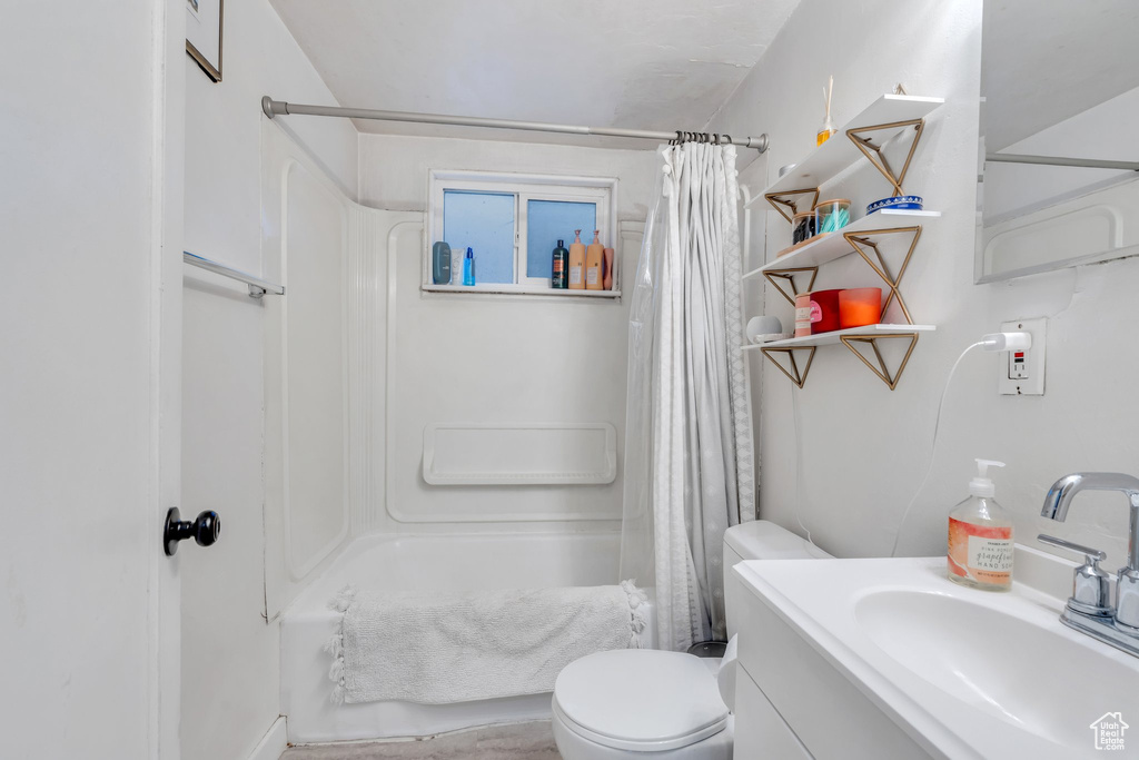 Full bathroom with shower / bathtub combination with curtain, toilet, and vanity