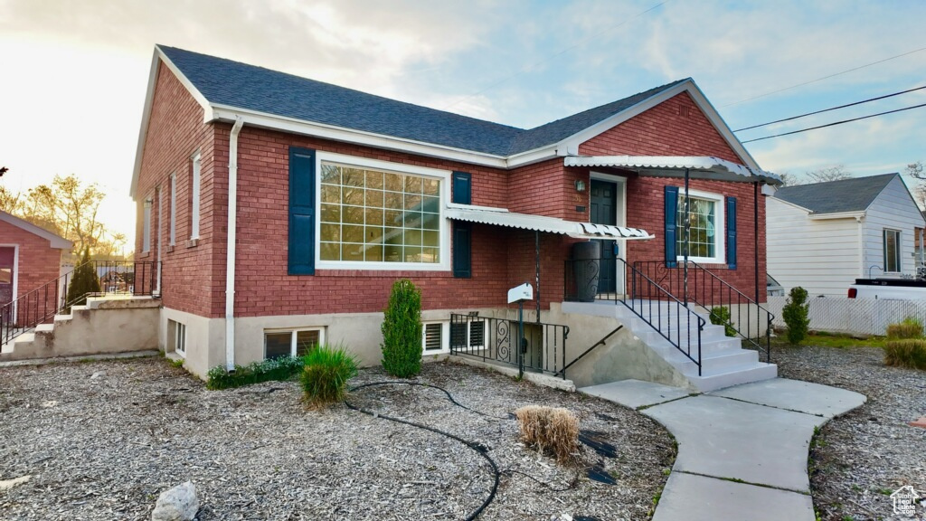 View of front of property featuring fence and brick siding
