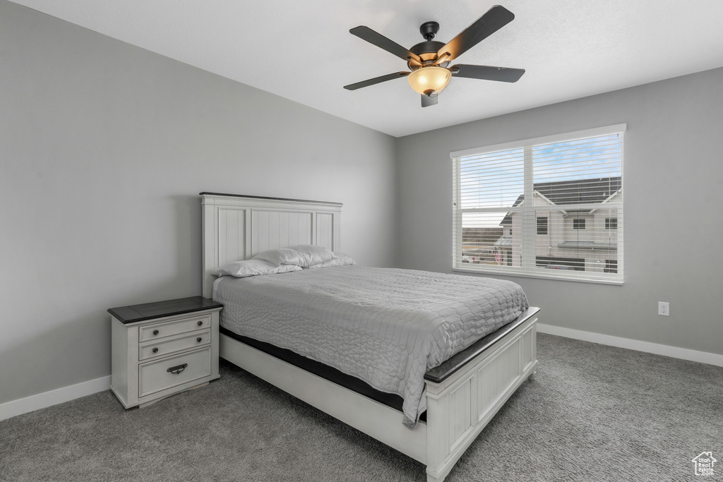 Carpeted bedroom with baseboards and a ceiling fan