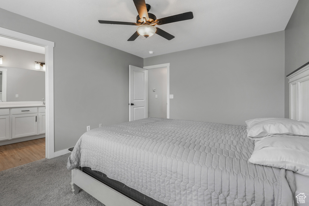 Bedroom with a ceiling fan, light carpet, connected bathroom, and baseboards
