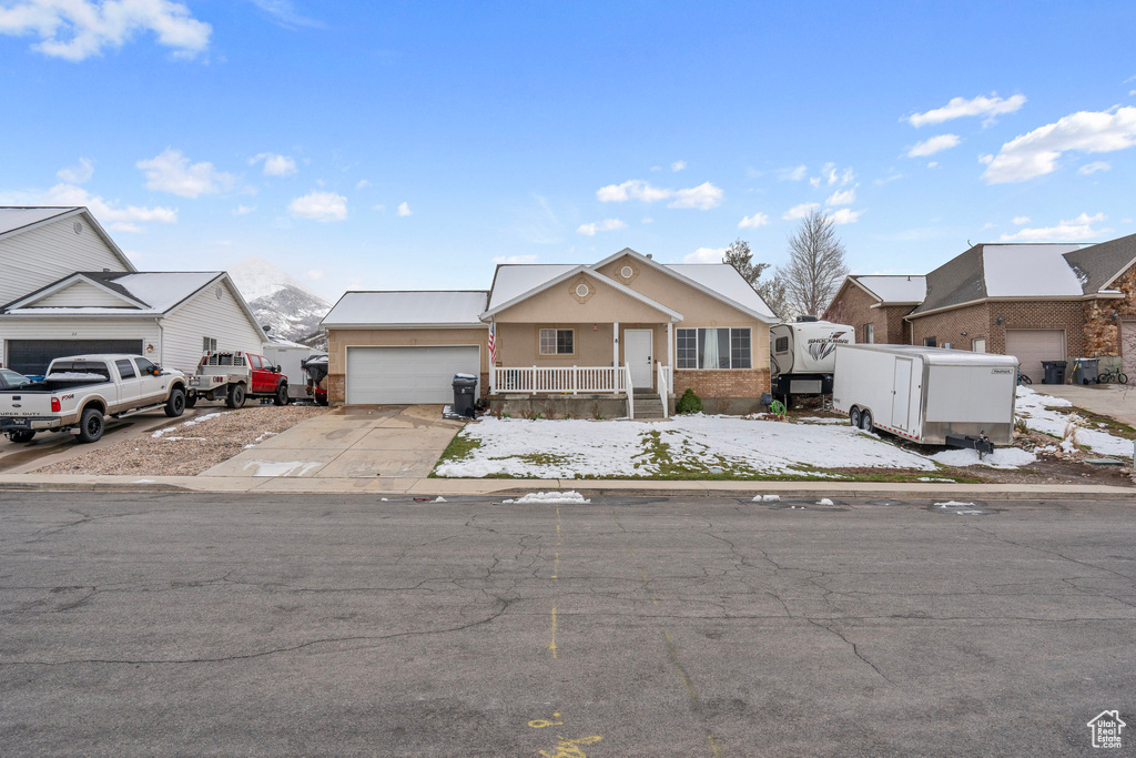 View of front of property featuring stucco siding, concrete driveway, and a garage