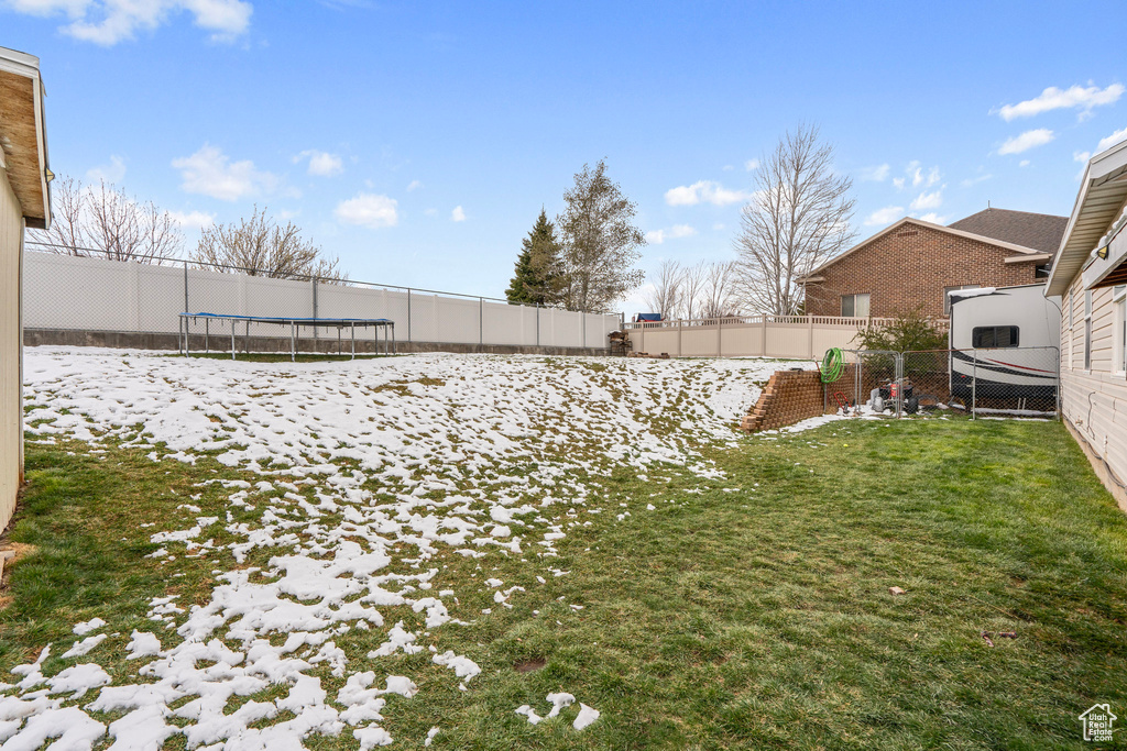 View of yard with a trampoline and a fenced backyard
