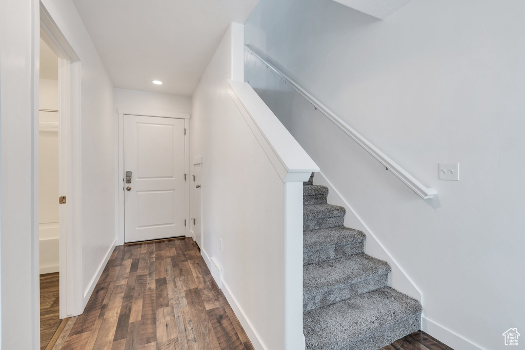 Staircase with baseboards, wood finished floors, and recessed lighting