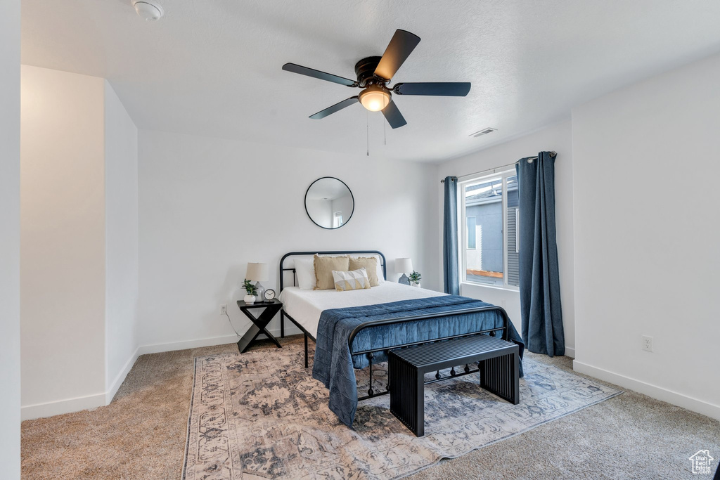 Bedroom with a ceiling fan, carpet floors, baseboards, and visible vents