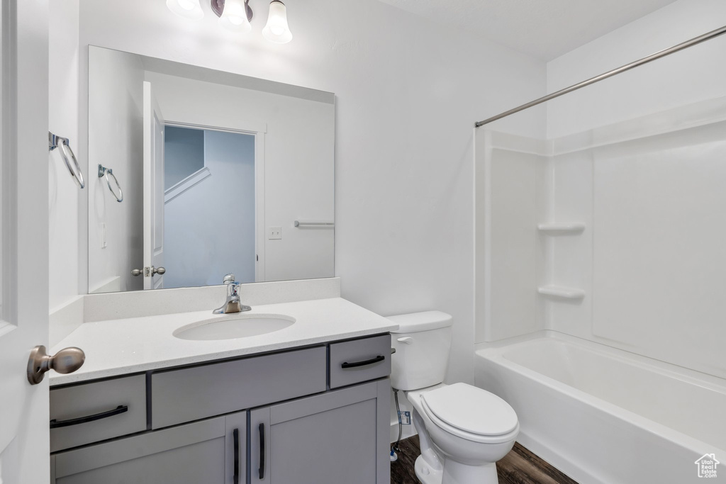 Bathroom with  shower combination, toilet, vanity, and wood finished floors