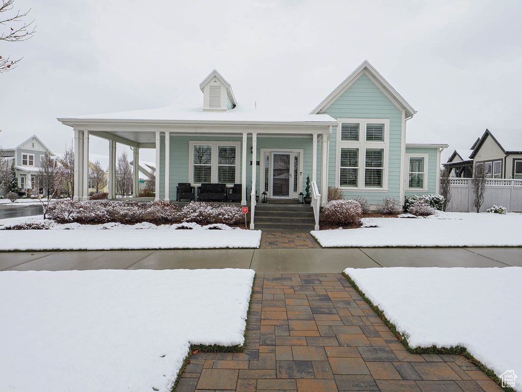 View of front of home featuring fence and a porch