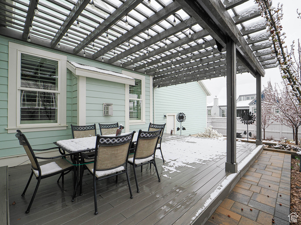 Wooden terrace with fence, outdoor dining space, and a pergola