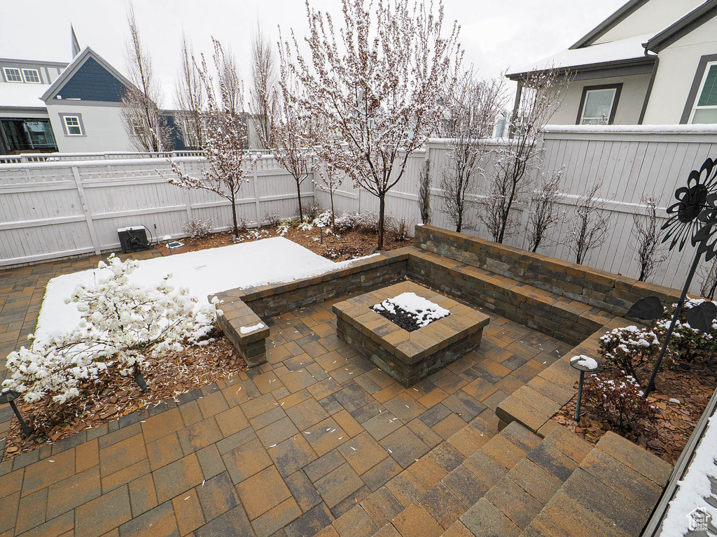 View of patio with an outdoor fire pit and a fenced backyard