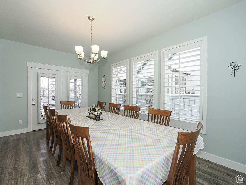Dining room with an inviting chandelier, baseboards, and dark wood finished floors