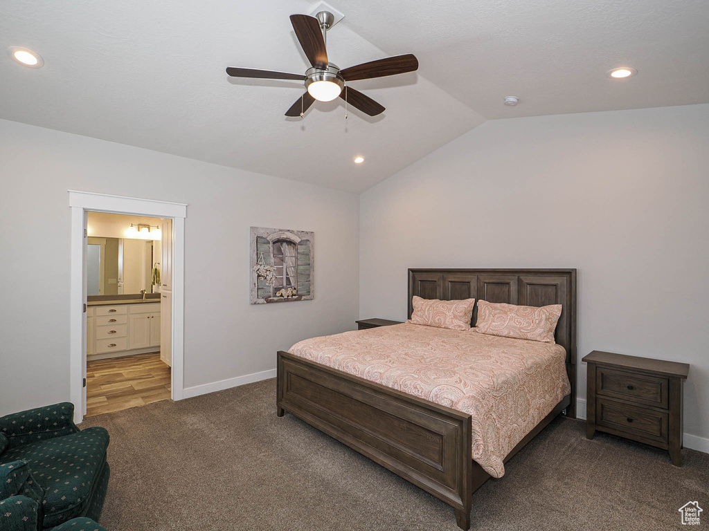 Bedroom featuring vaulted ceiling, carpet flooring, ensuite bathroom, baseboards, and recessed lighting