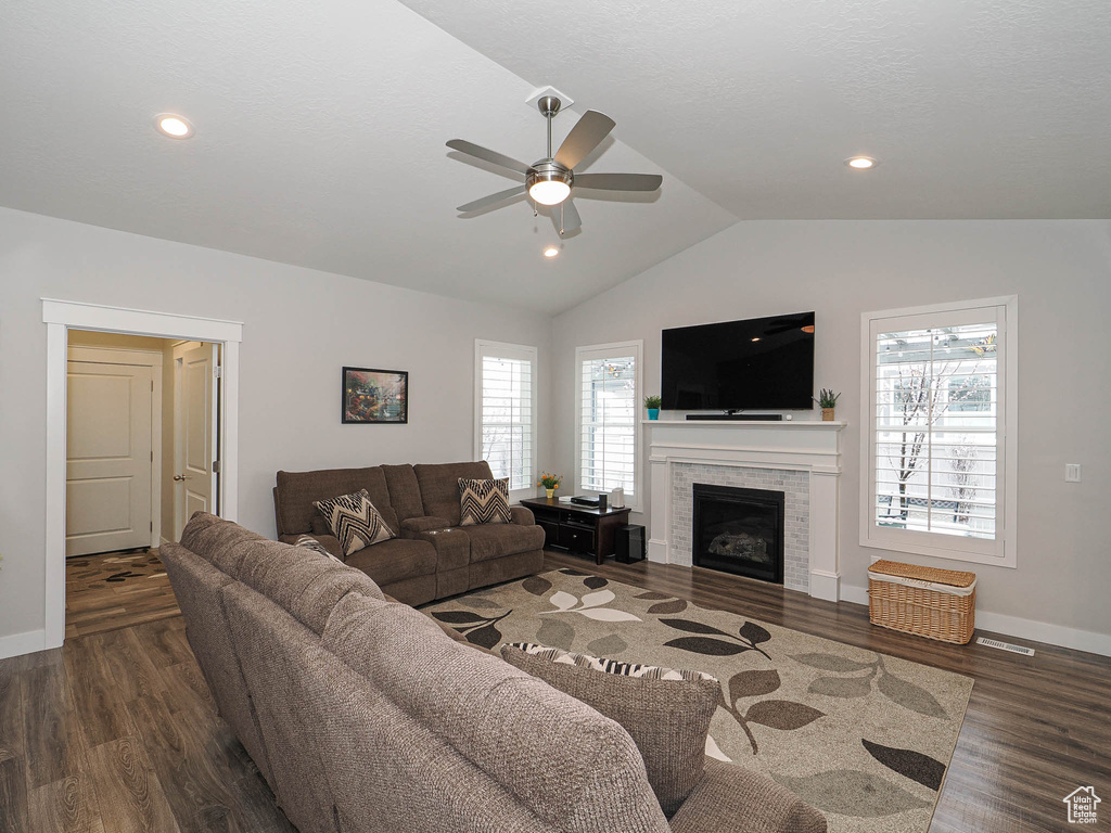 Living room featuring baseboards, ceiling fan, wood finished floors, and vaulted ceiling