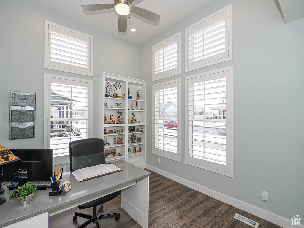 Home office featuring baseboards, dark wood-style flooring, visible vents, and a ceiling fan