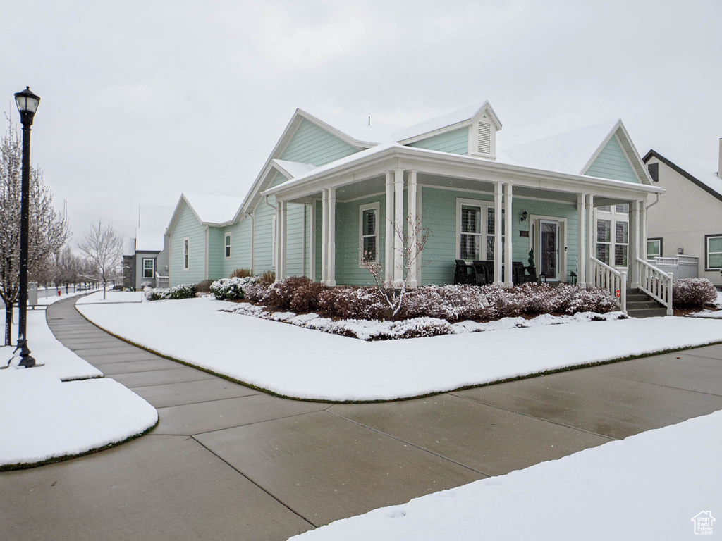 View of snowy exterior with a porch