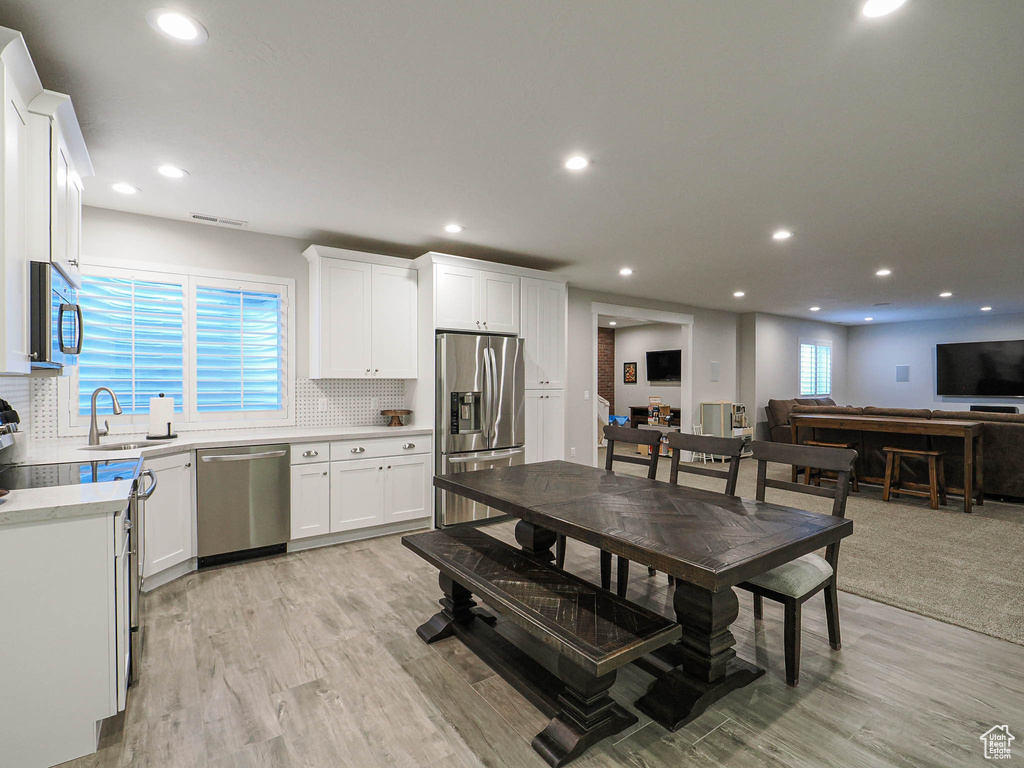 Kitchen featuring backsplash, light countertops, a sink, and appliances with stainless steel finishes