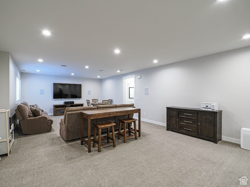 Carpeted living room with baseboards and recessed lighting