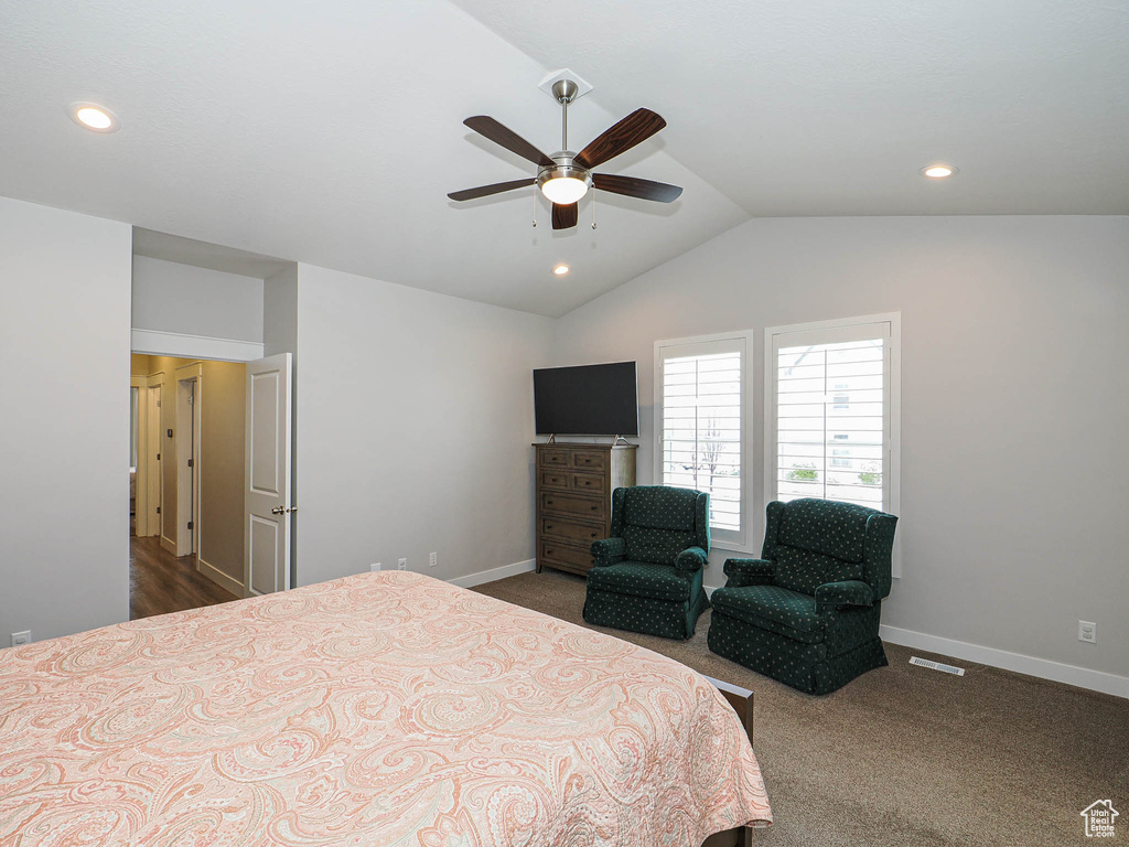 Bedroom featuring baseboards, lofted ceiling, visible vents, and dark carpet