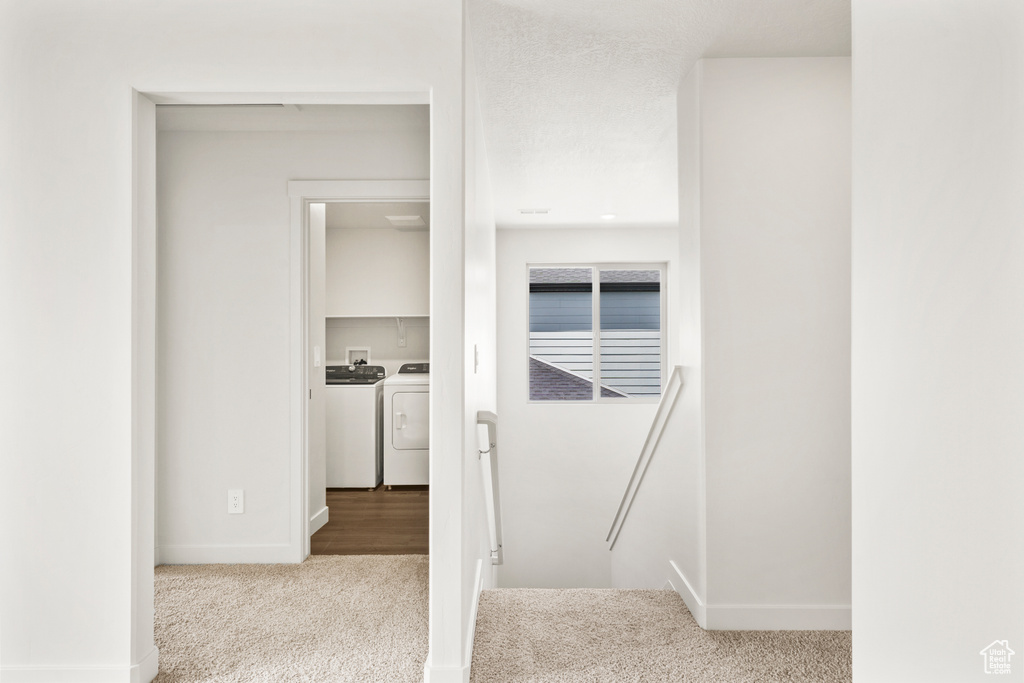 Interior space featuring baseboards, carpet flooring, and washer and dryer