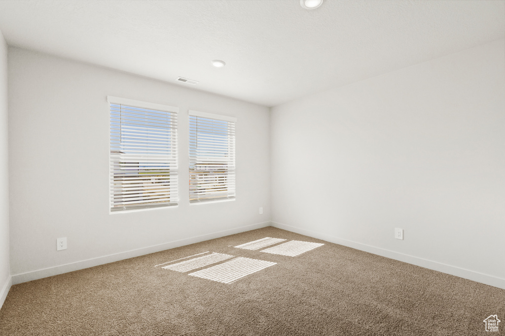Empty room featuring baseboards, carpet, recessed lighting, and visible vents
