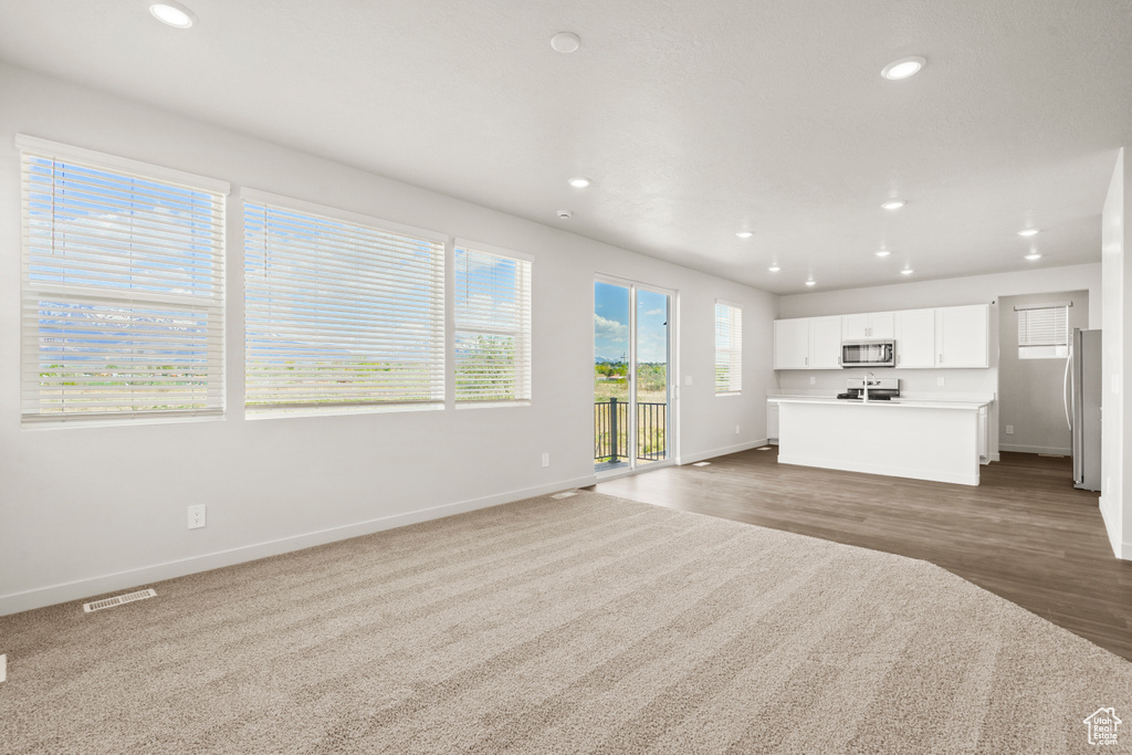 Unfurnished living room with recessed lighting, baseboards, visible vents, and wood finished floors