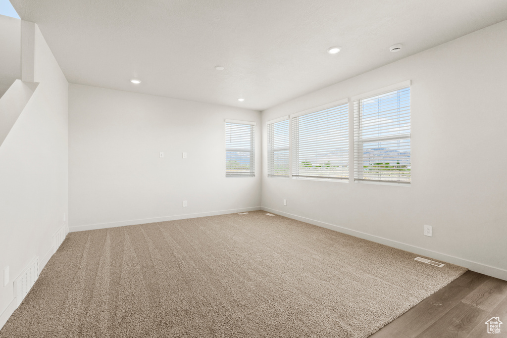 Empty room featuring baseboards, recessed lighting, wood finished floors, and visible vents