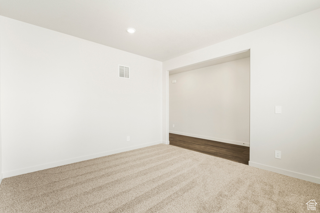 Carpeted empty room featuring visible vents, recessed lighting, and baseboards