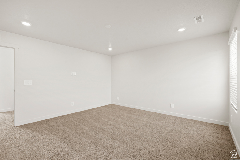 Carpeted empty room with visible vents, recessed lighting, and baseboards