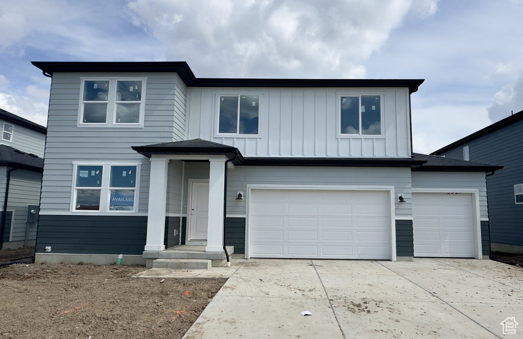 View of front facade with concrete driveway, an attached garage, and board and batten siding