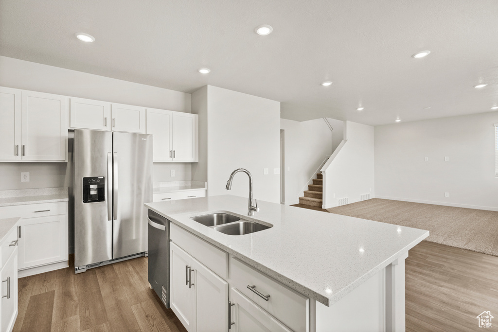 Kitchen featuring a sink, appliances with stainless steel finishes, and white cabinetry