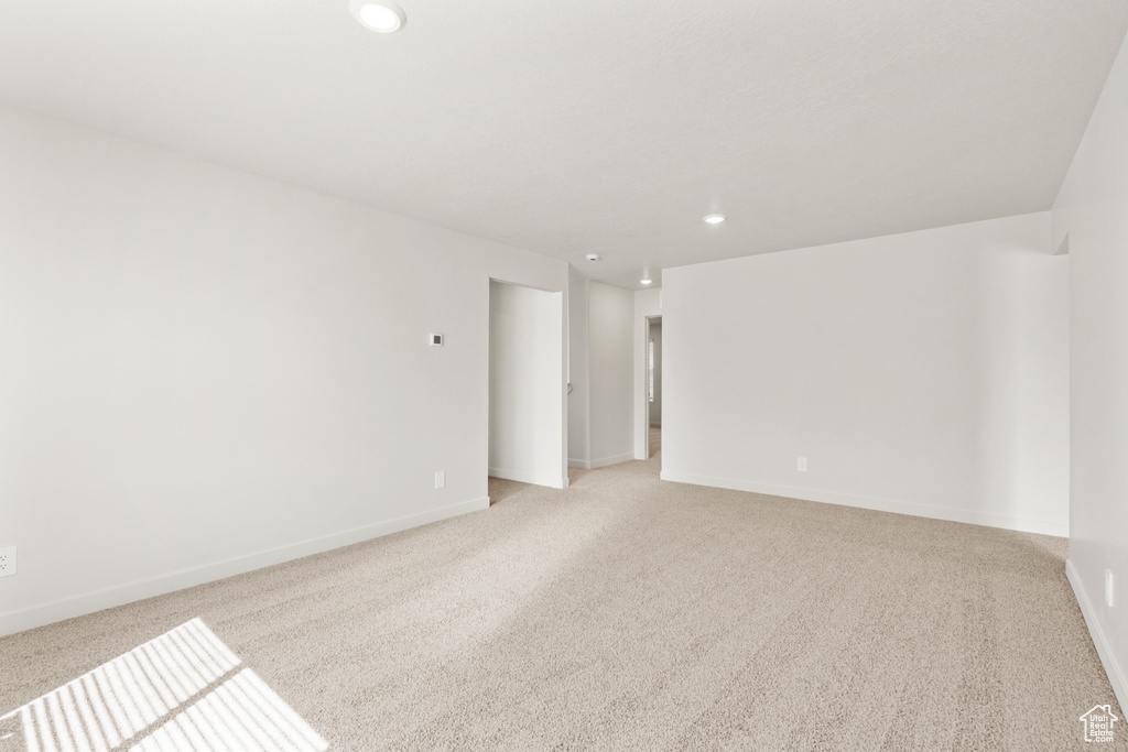 Unfurnished room featuring baseboards, recessed lighting, and light colored carpet