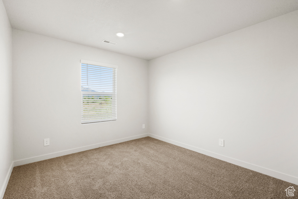 Carpeted spare room featuring baseboards, recessed lighting, and visible vents