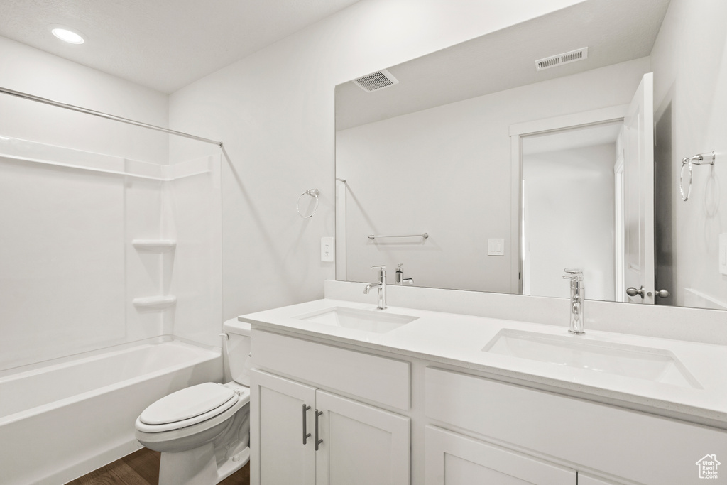 Bathroom with toilet, visible vents, and a sink