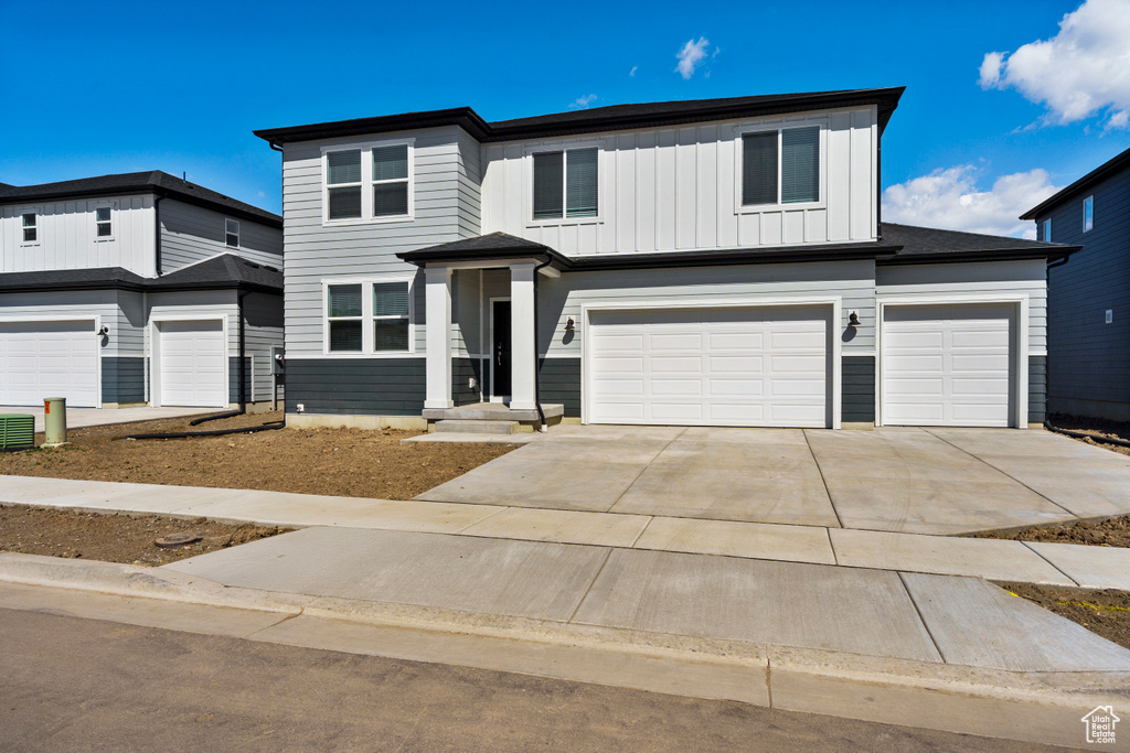 View of front of property featuring concrete driveway, board and batten siding, and a garage