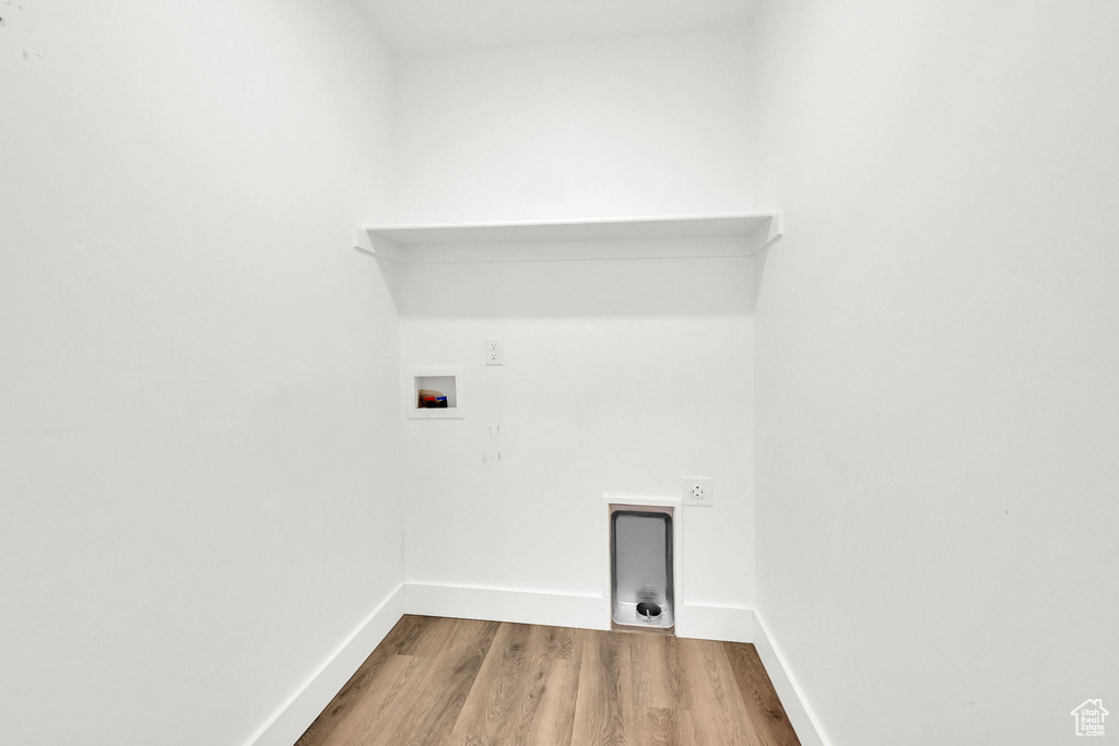 Laundry area with hookup for a washing machine, wood finished floors, and electric dryer hookup