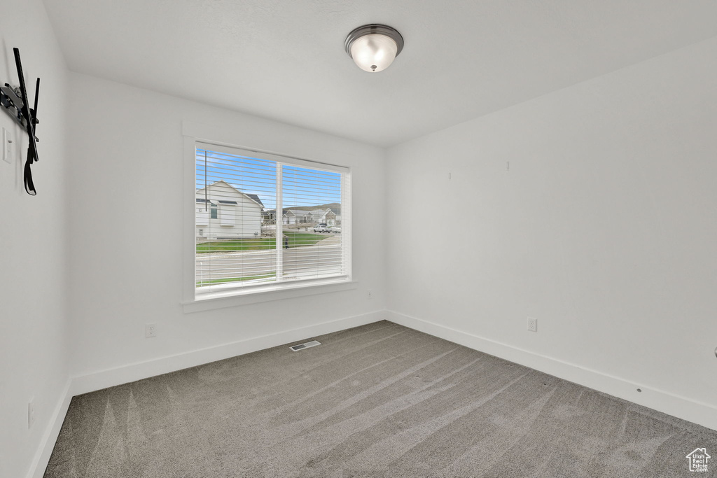 Carpeted empty room featuring baseboards