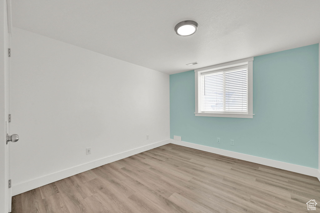 Unfurnished room with light wood-style flooring and baseboards