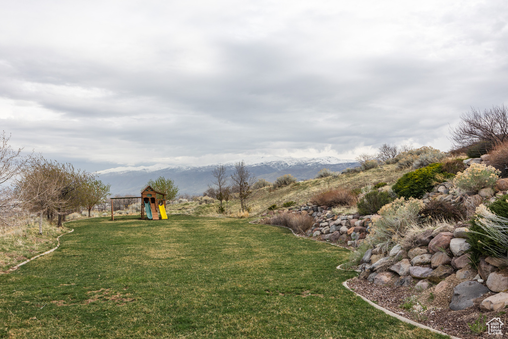 View of yard with a playground and a mountain view