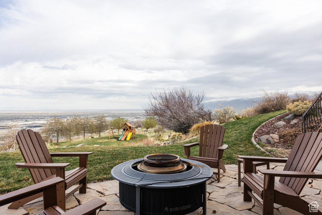 View of patio with a fire pit and a playground