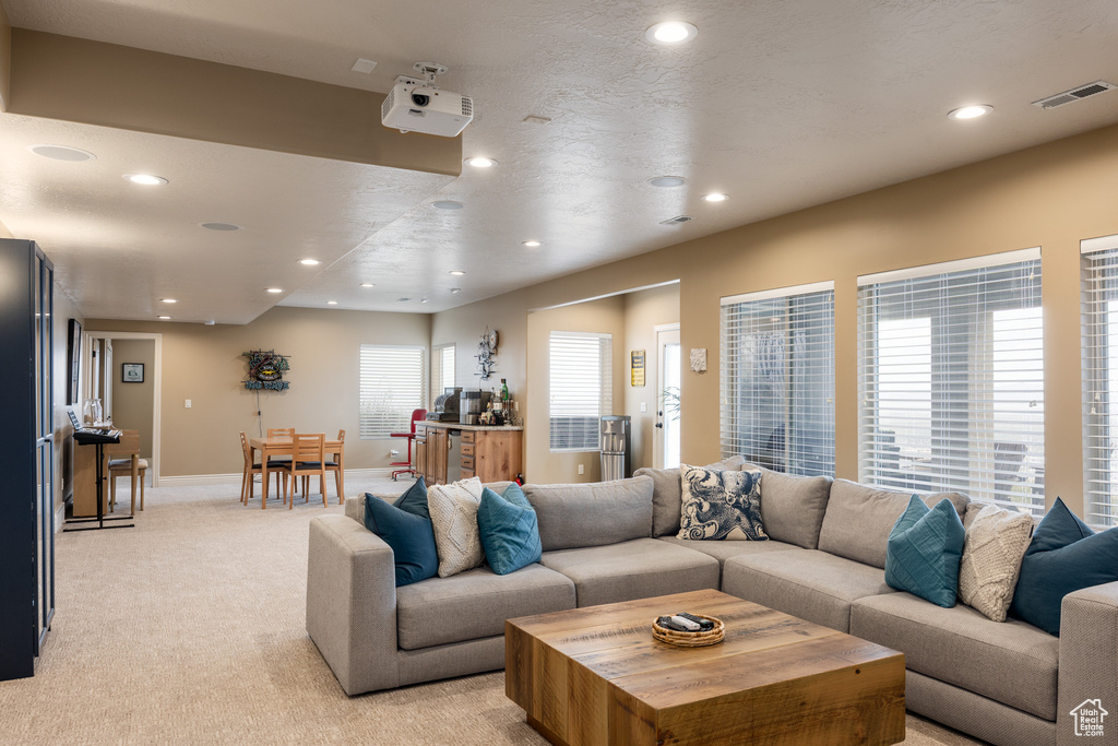 Living area with baseboards, visible vents, recessed lighting, and light colored carpet