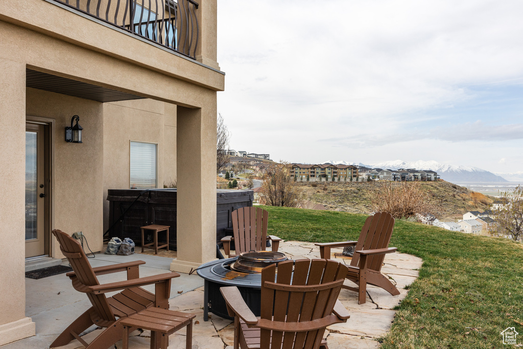 View of patio with a balcony, a fire pit, and a mountain view
