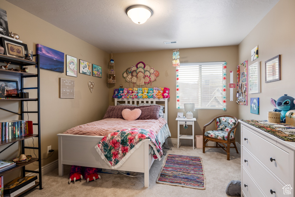 Bedroom featuring baseboards, visible vents, and light colored carpet