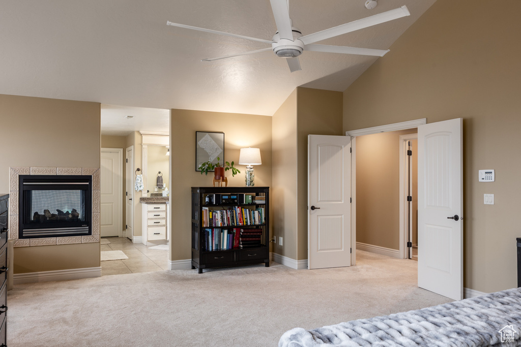 Bedroom with high vaulted ceiling, carpet floors, a tile fireplace, a ceiling fan, and baseboards