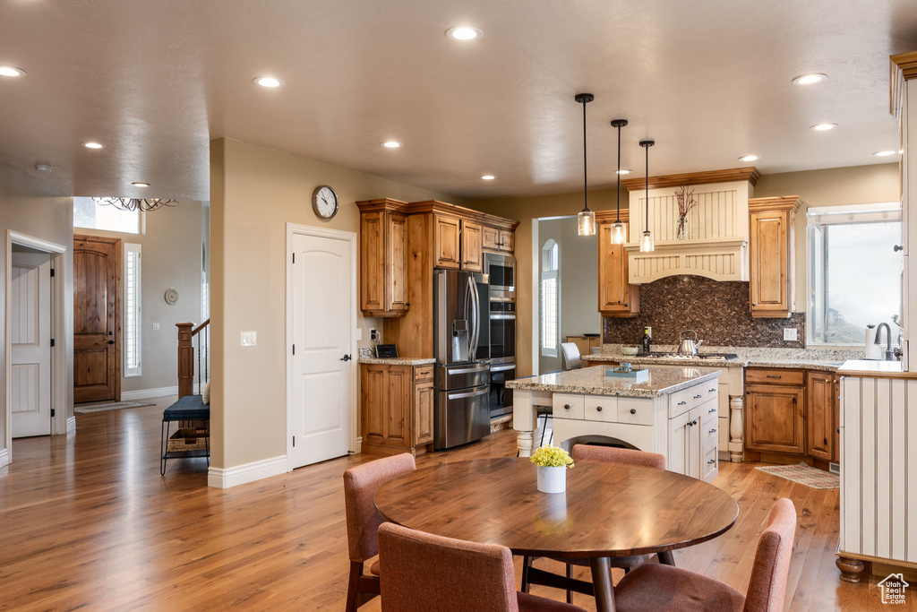 Kitchen featuring a sink, backsplash, light wood-type flooring, stainless steel appliances, and recessed lighting