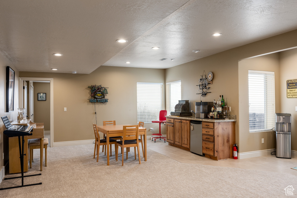 Dining space featuring a textured ceiling, baseboards, light colored carpet, and recessed lighting