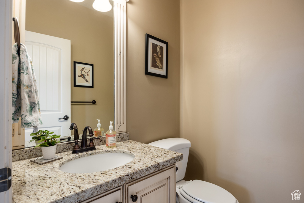 Half bathroom with toilet and vanity