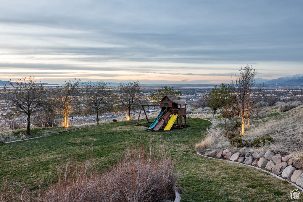 Yard at dusk featuring a playground