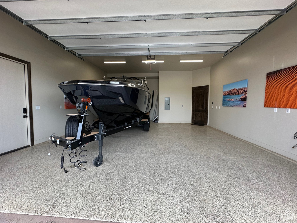 Garage featuring electric panel and a garage door opener