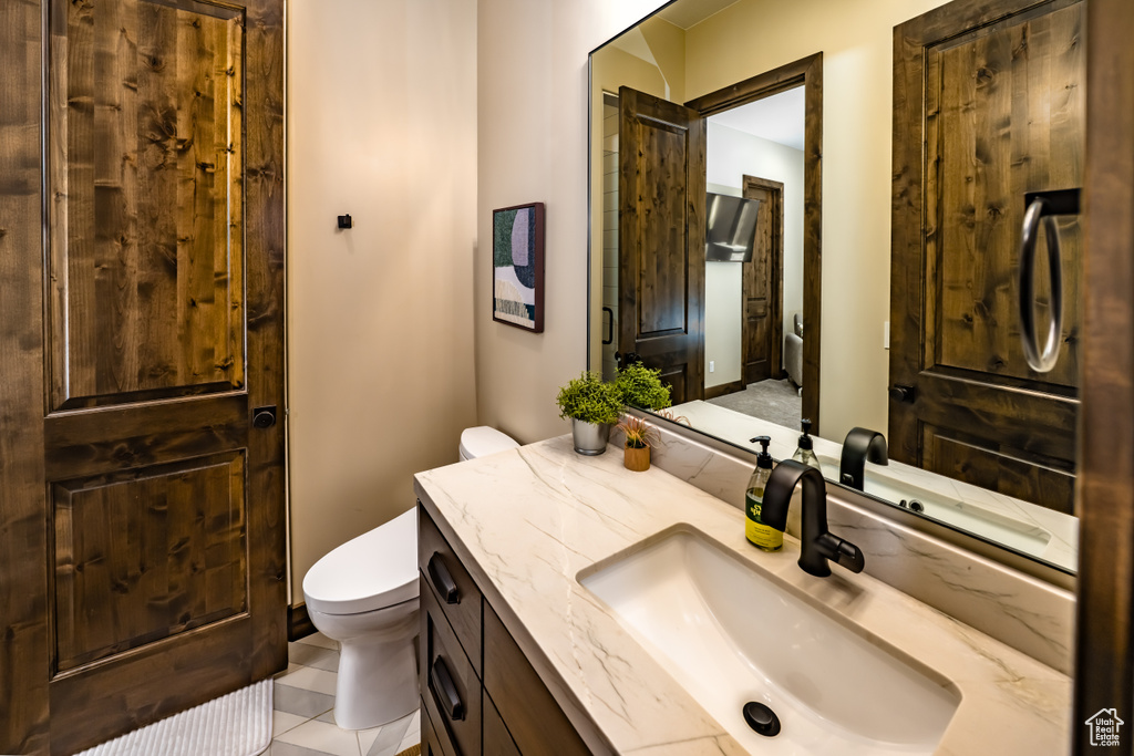 Bathroom featuring tile patterned floors, toilet, and vanity