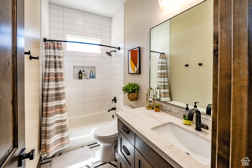 Bathroom with shower / bath combo with shower curtain, toilet, and vanity
